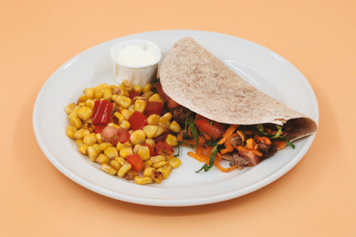 Taco on a plate with a red pepper and corn mixture 