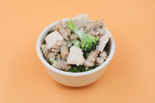  A bowl of pasta with broccoli and white sauce 