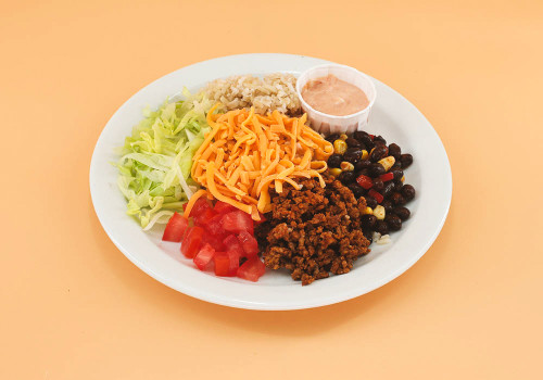  Beef, a variety of vegetables, cheese, salsa, and sour cream, served on brown rice. 